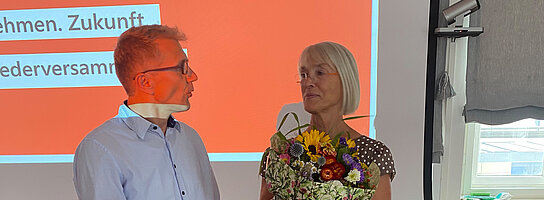 Herr Wissinger überreicht Frau Zeller vom RKW Bayern Blumen.