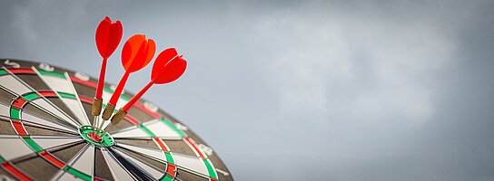 Dartscheibe mit 3 Darts im Zentrum