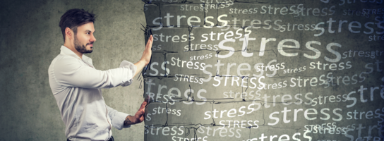 Ein Mann schiebt ein Plakat mit der Aufschrift "Stress" weg von sich