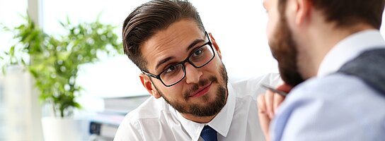 Zwei Geschäftsmänner im Gespräch miteinander.