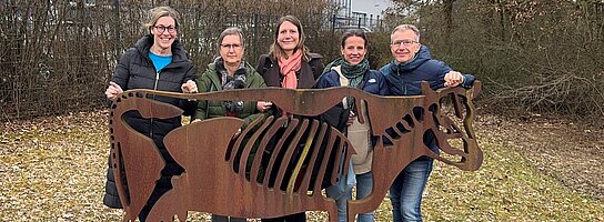 Das RKW Bayern (5 Personen) steht hinter einer lebensgroßen Kuh aus Stahll
