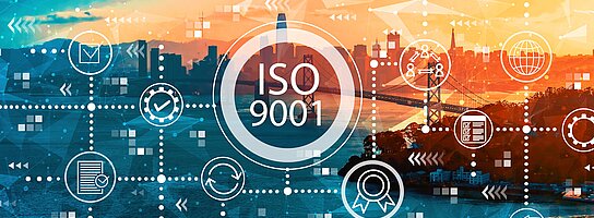 Vor einem Porträt auf eine große Stadt im Abendlicht steht ISO 9001.