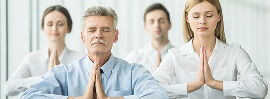 Geschäftsleute machen im Büro Übungen